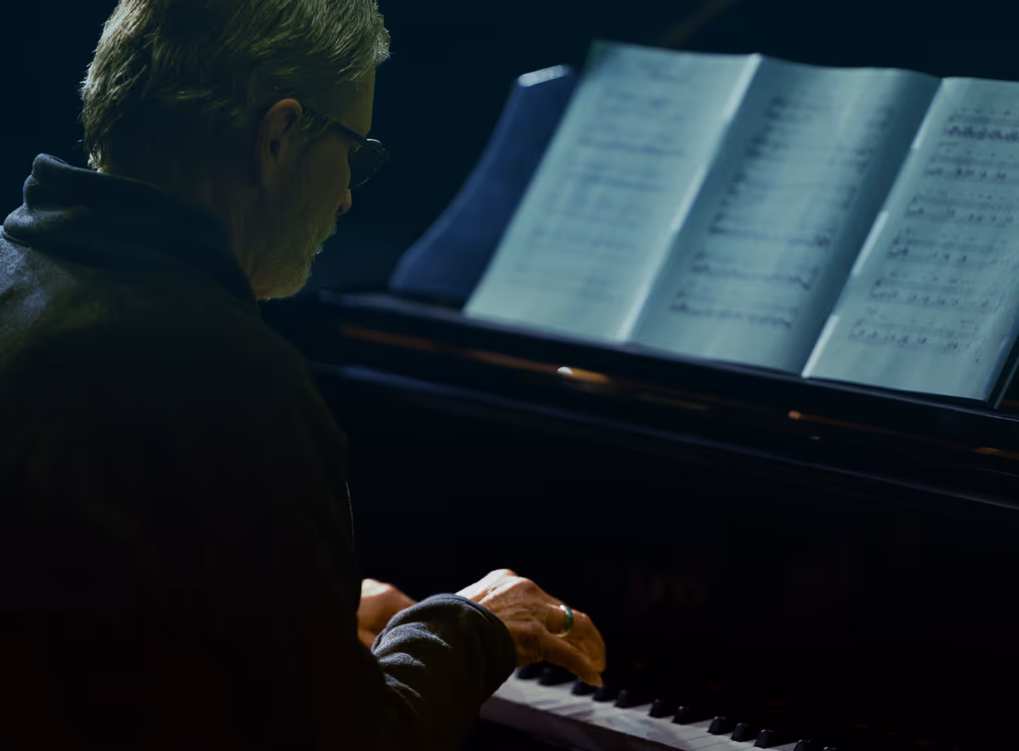 Pianist reading a chart at the keyboard