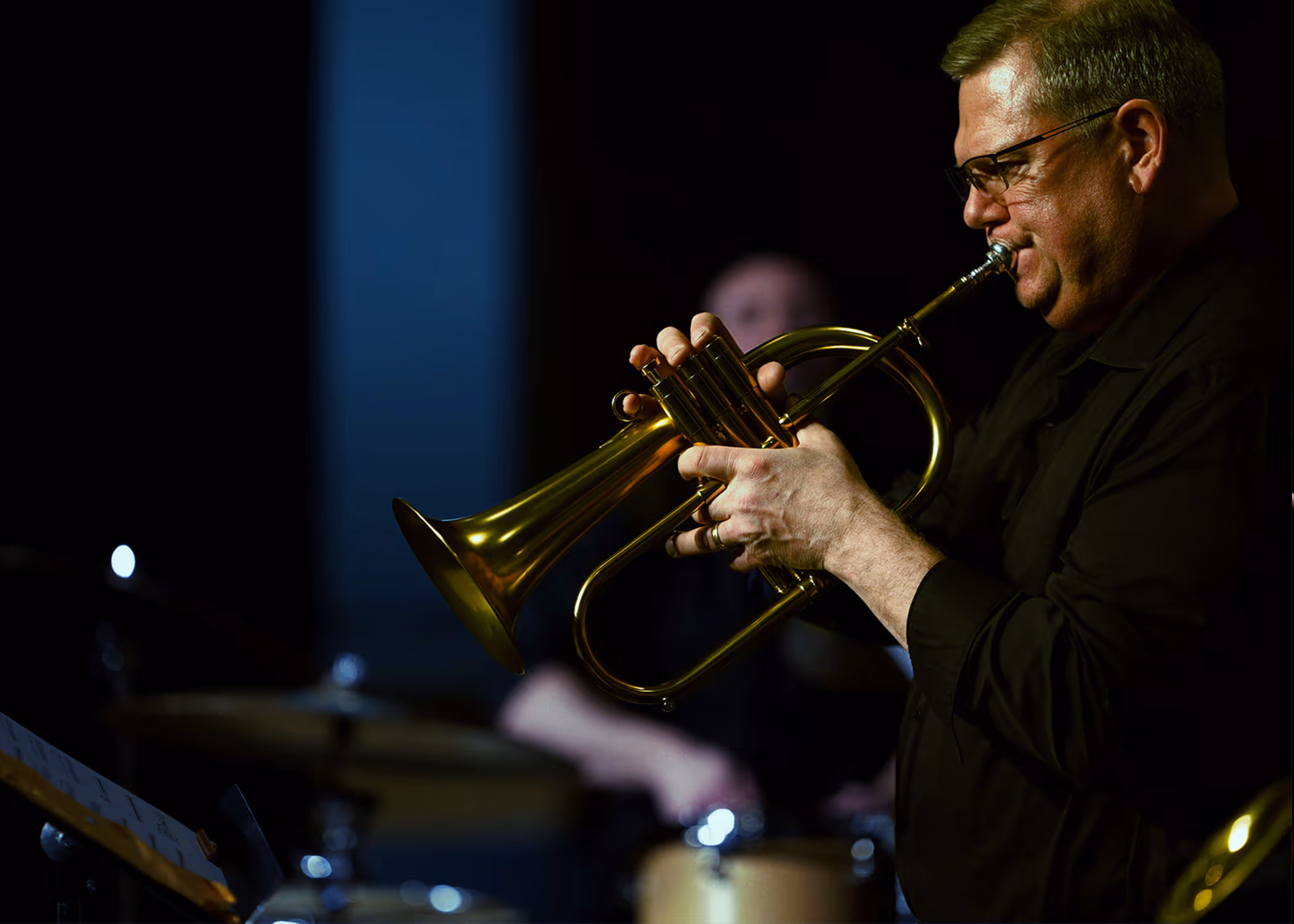 Flugelhorn player mid-solo with the drummer behind